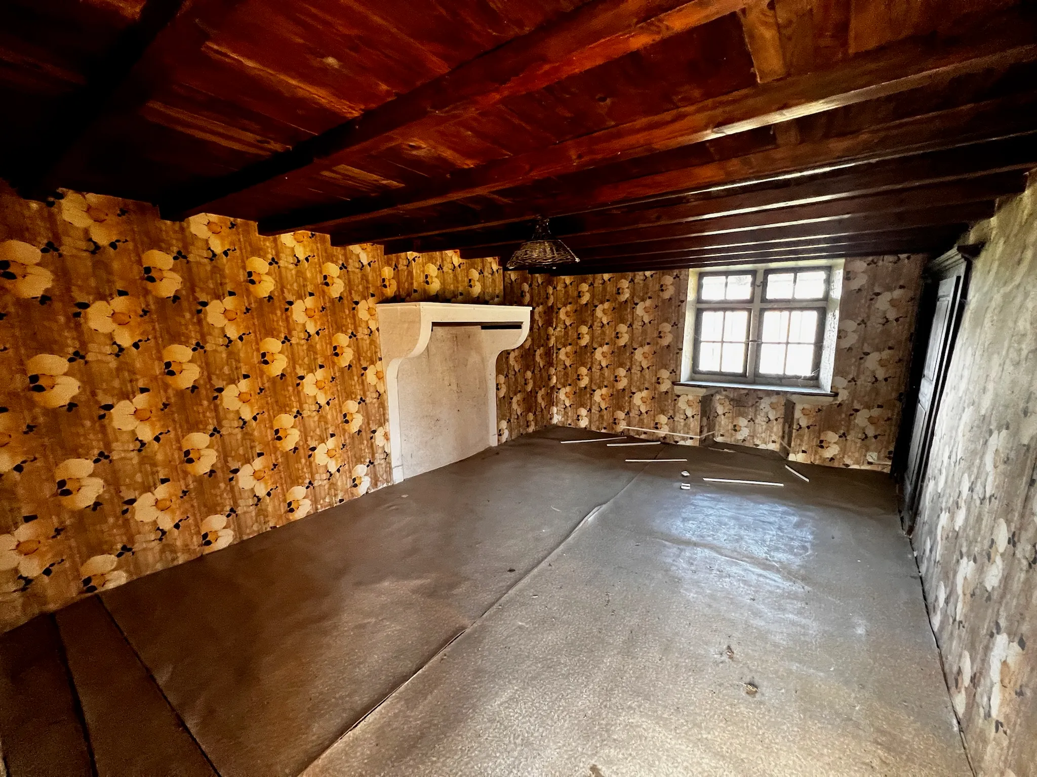 Cheminée monumentale en pierre dans une ferme en pisé