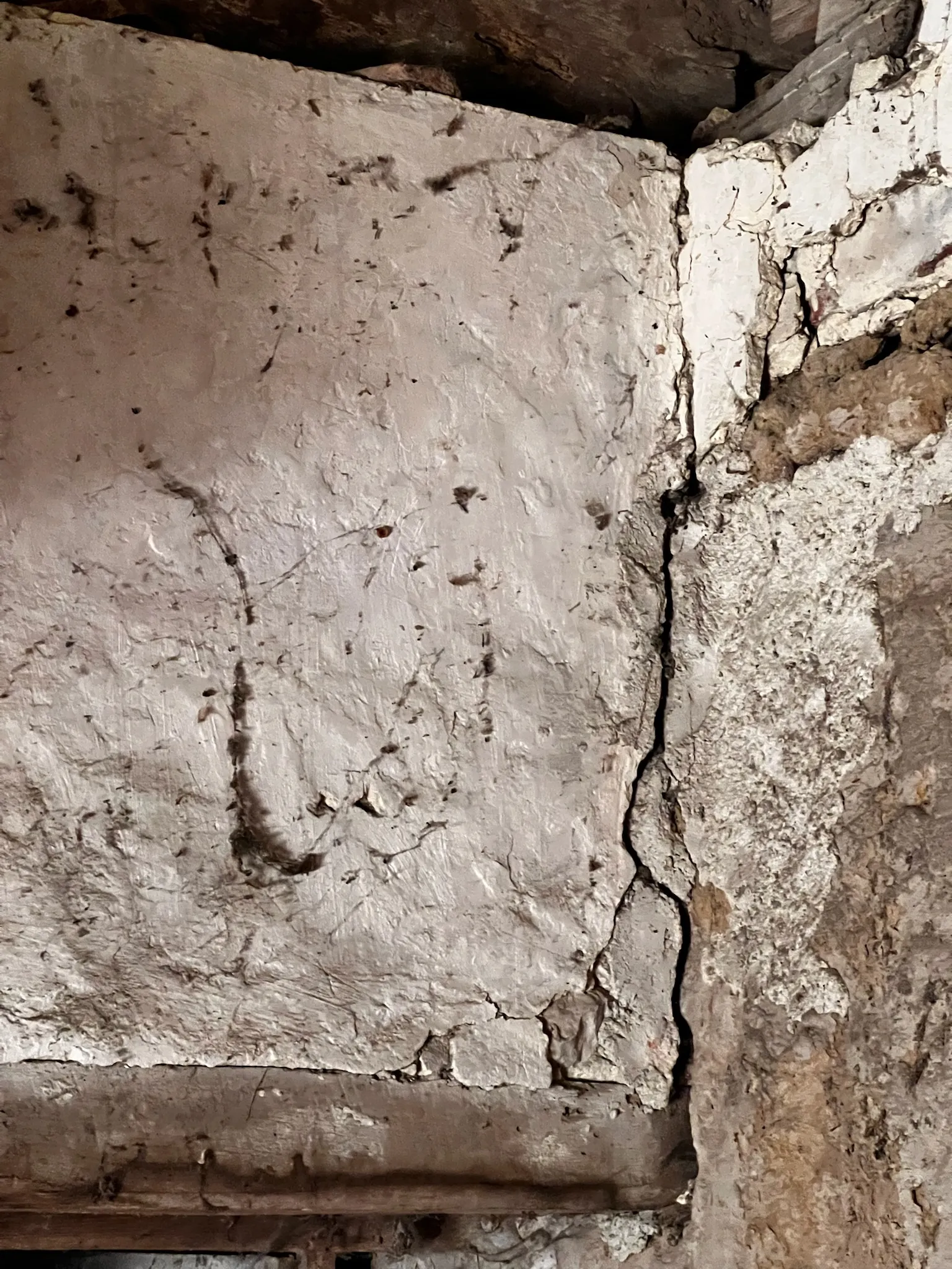 Grosse risque: la fissures dans les angles d'un mur en pisé