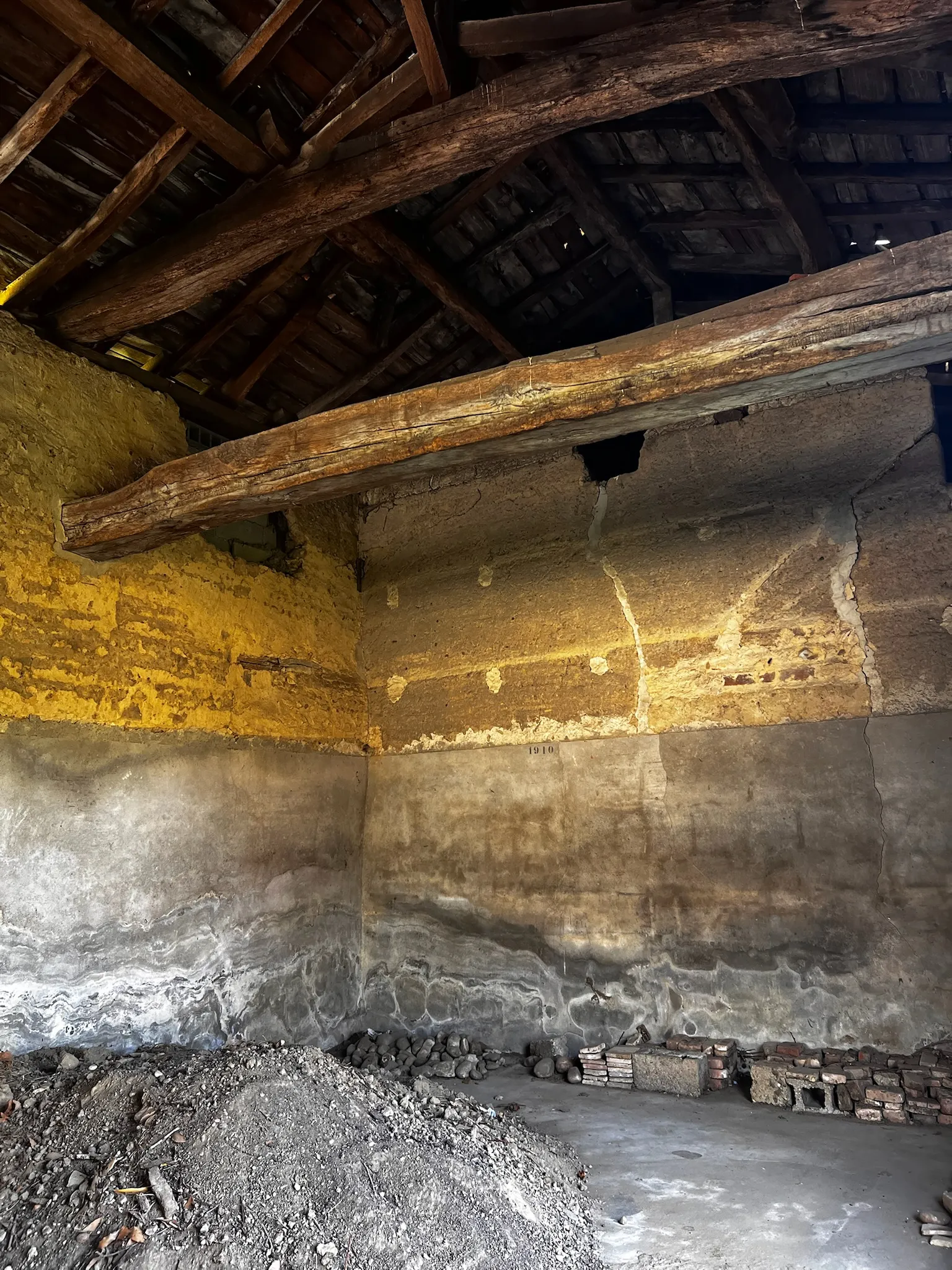 Inscription de restauration datée de 1910 sur un mur en pisé