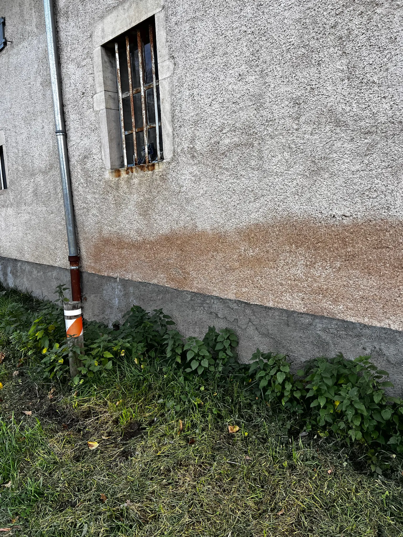 Soubassement enduit au ciment sur un mur en pisé